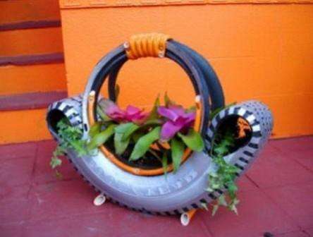 Поместите шину в удобном месте для клумбы, окрасьте ее красками и насыпьте в середину земли, высадите растения